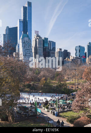 Trump Rink de Central Park sur une neige ensoleillée journée libre. L'ex-hôtes Wollman Rink de skaters ci-dessous les imposants bâtiments de la ville Banque D'Images