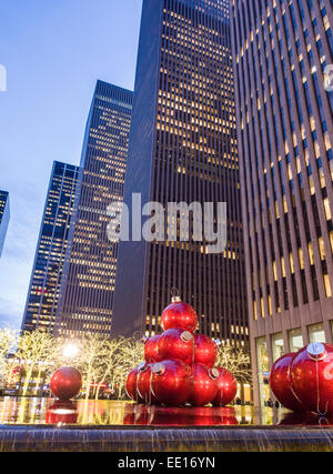 Boules de Noël géant rouge ci-dessous les tours. Voir la soirée de Noël Boules énormes placées dans le miroir d'eau et fou Banque D'Images