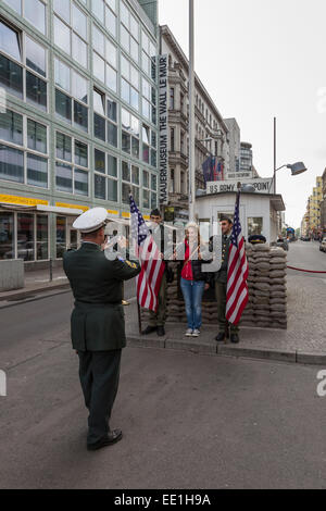 Touriste a prendre en photo avec l'acteur en uniforme des gardes-frontières, Checkpoint Charlie, Mitte, Berlin, Germany, Europe Banque D'Images