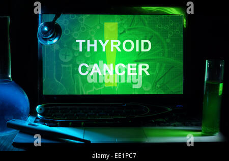 Ordinateur portable avec des mots le cancer de la thyroïde, tubes à essai et stéthoscope Banque D'Images