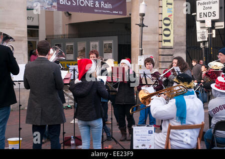 Wilton et District groupe jouant des chants de Noël dans la rue pour la collecte de charité Salisbury Wiltshire, UK Banque D'Images