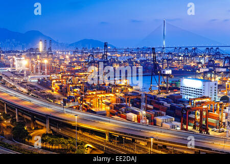 Terminal à conteneurs et tailleur de bridge à Hong Kong au coucher du soleil Banque D'Images