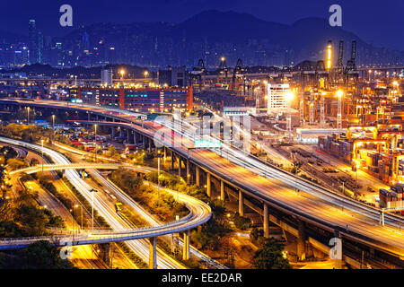 Terminal à conteneurs et tailleur de bridge à Hong Kong au coucher du soleil Banque D'Images