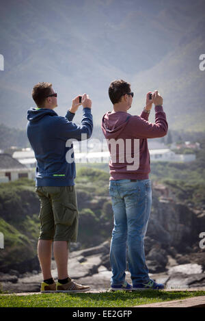 Deux hommes de photographier les baleines australes à Hermanus dans le Western Cape, Afrique du Sud. Ils sont à l'aide d'appareils photo compacts. Banque D'Images