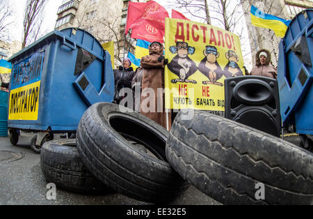 Kiev, Ukraine. 13 Jan, 2015. Les pneus de voiture et les poubelles sont des symboles de la lustration. -- Les travailleurs de l'usine de confiserie Jytomyr besoin d'écarter le procureur général de Lukraine Vitaly Yarema et son premier adjoint Oleg Bachun. Kiev, le 13 janvier 2015, l'usine fait du piquetage devant le procureur général pour la neuvième fois. Traditionnellement, les protestataires mis les poubelles, des bannières et de la batterie dans des fûts métalliques. Crédit : Igor Golovnov/Alamy Live News Banque D'Images