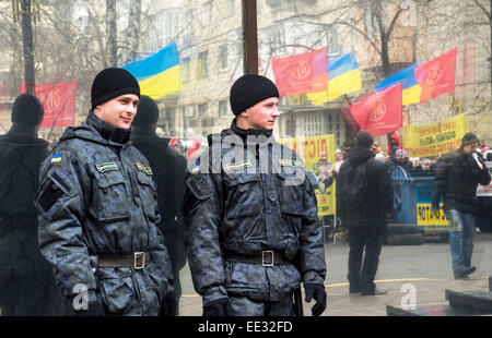 Kiev, Ukraine. 13 Jan, 2015. Deux agents de police en regardant l'action sur le fond de verre, qui reflète les manifestants. -- Les travailleurs de l'usine de confiserie Jytomyr besoin d'écarter le procureur général de Lukraine Vitaly Yarema et son premier adjoint Oleg Bachun. Kiev, le 13 janvier 2015, l'usine fait du piquetage devant le procureur général pour la neuvième fois. Traditionnellement, les protestataires mis les poubelles, des bannières et de la batterie dans des fûts métalliques. Crédit : Igor Golovnov/Alamy Live News Banque D'Images