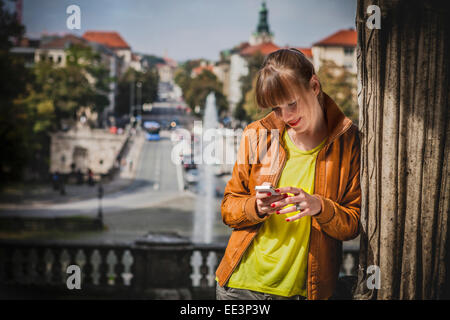 Jeune femme à l'extérieur de la messagerie texte, Munich, Bavière, Allemagne Banque D'Images