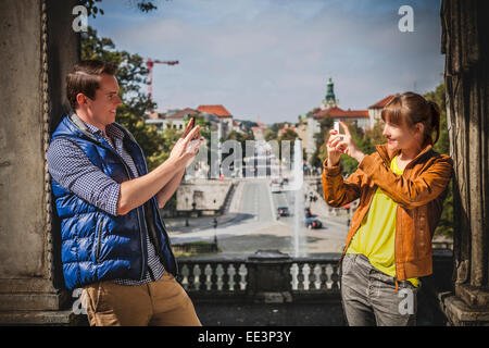 Jeune couple à prendre des photos de l'autre, Munich, Bavière, Allemagne Banque D'Images