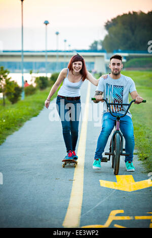 Jeune couple avec vélo BMX et skateboard en plein air