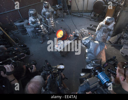 Burbank, Californie, USA. 13 Jan, 2015. Plusieurs dizaines de membres de la presse réunis autour de caméras en tant que travailleurs pour les moulages en bronze fondu que sera cette années 2015 21st Annual SAG Awards.-----La moulée en bronze pour le prix annuel 2015 de l'Acteur Écran Guild Awards ont été exprimées à l'American Fine Arts fonderie à Burbank, mardi matin. Prendre 2 heures pour chauffer, bronze fondu est prêt lorsqu'il atteint environ 1800 degrés avant qu'il soit coulé dans des moules. Les prix sont d'abord fabriqués en cire avant situé dans le sable spéciale haute température. Les moules sont chauffés jusqu'à 1800 degrés comme w Banque D'Images