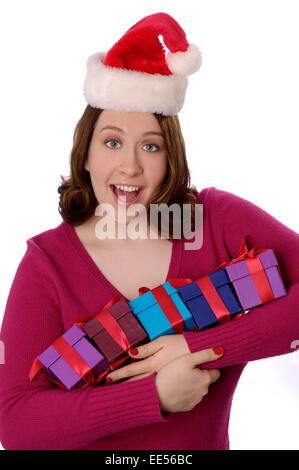 Stock photo d'une jeune femme portant un noël santa claus hat, holding de petits emballages. Banque D'Images