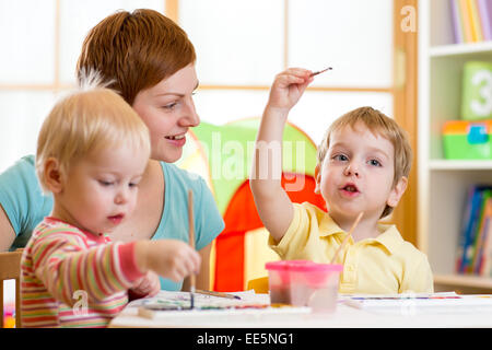 L'enseignement de mère mignon ses enfants à peindre Banque D'Images