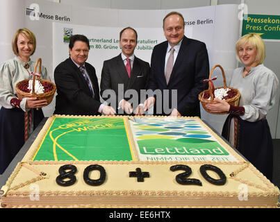 Christoph Minhoff (gestionnaire de l'association faîtière de l'industrie alimentaire, L-R), Christian Goeke (gestionnaire du parc des expositions Messe Berlin) et Joachim Rukwied (Président de l'Association des agriculteurs allemands) Couper un gâteau d'anniversaire avec le Letton hôtesses avant le début de la conférence de presse d'ouverture de la 80e Semaine verte à Berlin, Allemagne, 14 janvier 2015. Plus de 1 600 exposants présentent leurs produits dans 26 complexes de hall sous la Funkturm Berlin du 16 jusqu'au 25 janvier 2015. La Lettonie est cette année le pays partenaire. PHOTO : BERND SETTNIK/dpa Banque D'Images