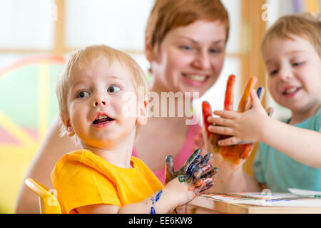 Cute woman playing et la peinture avec les enfants Banque D'Images