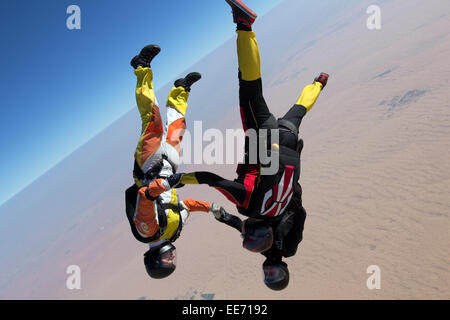 L'équipe de parachutisme est holding hand ensemble après qu'ils ont sauté d'un avion. Ils ainsi s'amuser et jouer dans le ciel bleu. Banque D'Images