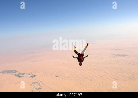 Parachutiste dans une position grenouille freefly headdown est survolant un grand désert. La jeune fille est ainsi voler avec plus de 120km/h Banque D'Images