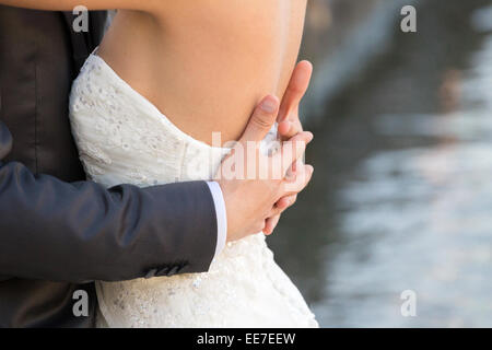 Couple marié de jour de leur mariage, détail du buste et des bras. Banque D'Images