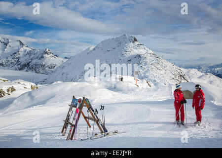 Deux moniteurs de ski femme suisse en attente en haut des pistes dans la station de sports d'hiver dans les Alpes, Valais / Valais, Suisse Banque D'Images