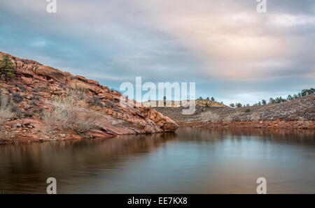 Calme crépuscule sur un lac avec des falaises redstone - Horsetooth Reservoir près de Fort Collins dans le nord du Colorado Banque D'Images