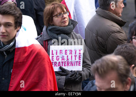 Une femme avec un slogan, les valeurs de la République française : liberté, égalité, fraternité au cours de rassemblement 'Je suis Charlie' vigil Banque D'Images