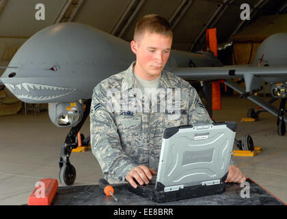 Navigant de première classe Troy Spence, 62e Escadron de reconnaissance de la Force expéditionnaire du Canada s'occupe de l'entretien d'un drone MQ-1 Predator à la base aérienne de Bagram, en Afghanistan, dans le cadre de l'opération Enduring Freedom. Voir la description pour plus d'informations. Banque D'Images