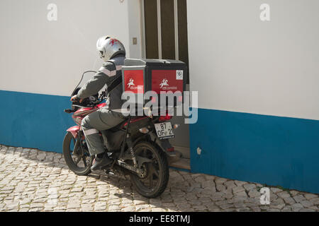 Postman portugais sur la distribution du courrier sur une moto Banque D'Images
