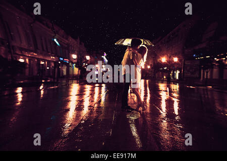 L'amour sous la pluie / Silhouette de kissing couple under umbrella Banque D'Images