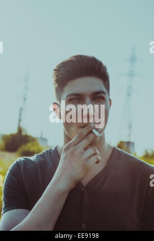 Close up portrait of young man smoking cigarette Banque D'Images