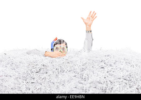 Homme plongée dans une pile de papier déchiqueté isolé sur fond blanc Banque D'Images