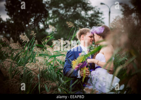 Young attractive young couple holding hands outdoors à côté de tree by lake Banque D'Images