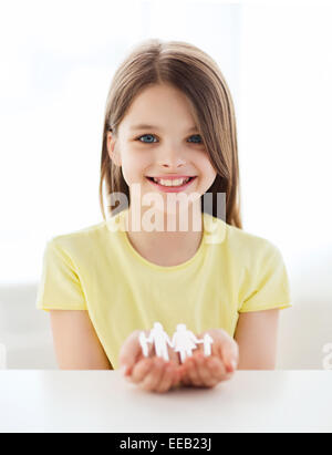 Smiling little girl montrant la famille homme papier Banque D'Images