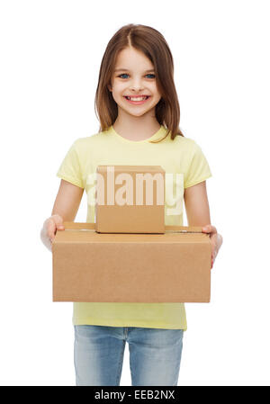 Smiling little girl avec de nombreuses boîtes de carton Banque D'Images