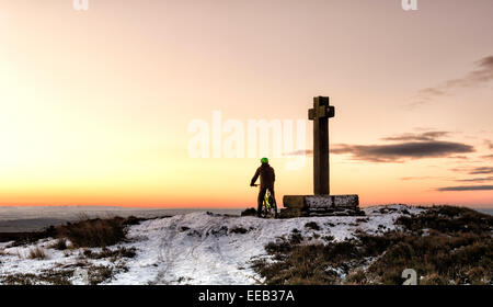 Un vélo de montagne en admirant le lever du soleil à Ana Croix sur Rosedale moor Banque D'Images