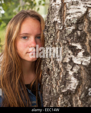 Jeune teen girl with long hair portrait près de l'arbre. Banque D'Images