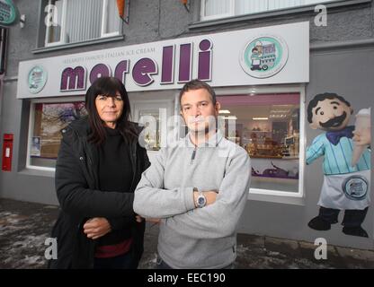 Ballycastle, Irlande du Nord, Royaume-Uni. 14 janvier, 2015. Romeo et Deidre Morelli à l'extérieur de leur monde célèbre glacier de Ballycastle, l'Irlande du Nord où ils sont confrontés à des poursuites judiciaires pour l'érection de la 'morelli' (photo) Service de planification sont les oblige à enlever leurs enseigne lumineuse par début de février ou le visage heafty amendes de 2500 € et 250 € par jour après une date donnée. Crédit : Steven McAuley/Alamy Live News Banque D'Images