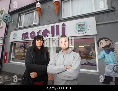 Ballycastle, Irlande du Nord, Royaume-Uni. 14 janvier, 2015. Romeo et Deidre Morelli à l'extérieur de leur monde célèbre glacier de Ballycastle, l'Irlande du Nord où ils sont confrontés à des poursuites judiciaires pour l'érection de la 'morelli' (photo) Service de planification sont les oblige à enlever leurs enseigne lumineuse par début de février ou le visage heafty amendes de 2500 € et 250 € par jour après une date donnée. Crédit : Steven McAuley/Alamy Live News Banque D'Images