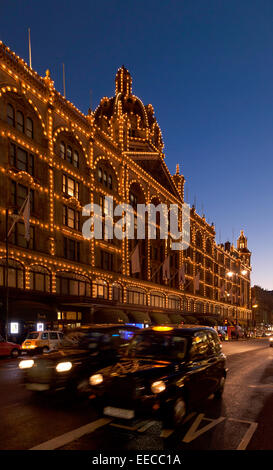 Harrods, Knightsbridge, Londres de nuit avec un taxi de Londres ; London UK Banque D'Images