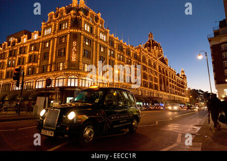 Harrods, Knightsbridge, Londres de nuit avec un taxi de Londres ; London UK Banque D'Images