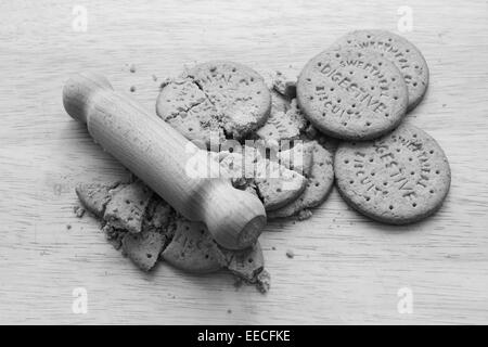Ensemble et biscuits digestifs écrasé sur une planche avec un petit rouleau à pâtisserie en bois - transformation monochrome Banque D'Images