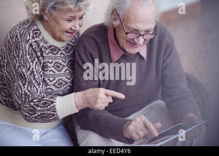 Mari et femme âgée using digital tablet Banque D'Images