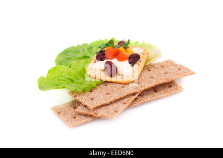 Les crackers piles avec des légumes frais et crème isolé sur fond blanc. Banque D'Images