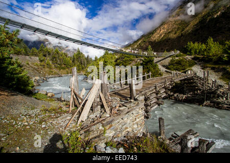 Ponts sur une rivière dans l'Himalaya du Népal, vu tout le long du circuit de l'Annapurna trekking. Banque D'Images