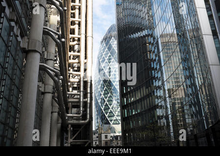 Le bâtiment de la Lloyds reflétée dans l'architecture moderne d'un édifice de verre en face de la ville de Londres, Royaume-Uni. Cette petite région est bien connue pour son design architectural novateur. Banque D'Images