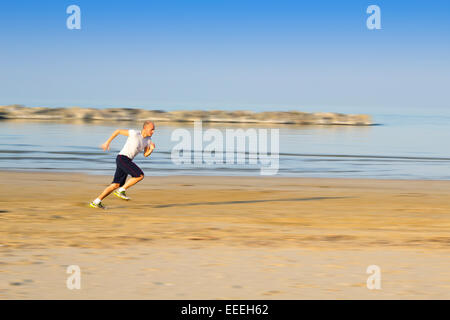 Garçon qui trains circulant sur la plage Banque D'Images