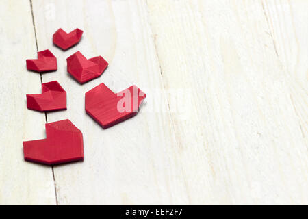 Joli coeur rouge est sur le plancher de bois blanc. Photographie de la 3d de l'objet imprimé. Banque D'Images