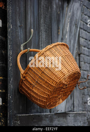 Main vide panier suspendu à la porte en bois. Banque D'Images