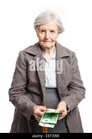 Senior woman counting money while standing over white background Banque D'Images