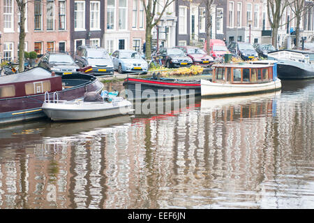 Scène du canal typique d'Amsterdam avec des maisons et bateaux reflétée sur l'eau calme Banque D'Images