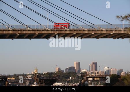 Un bus à impériale rouge traverse l'ANZAC Bridge juste avant le coucher du soleil - Sydney, Australie. Banque D'Images