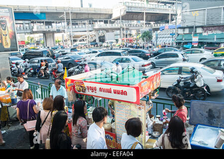 Des scooters,voitures, l'attente aux feux de circulation à l'intersection de Asok et trafic .Sukhumvit,vente,vendeurs,Bangkok,Thaïlande,Asie. Banque D'Images